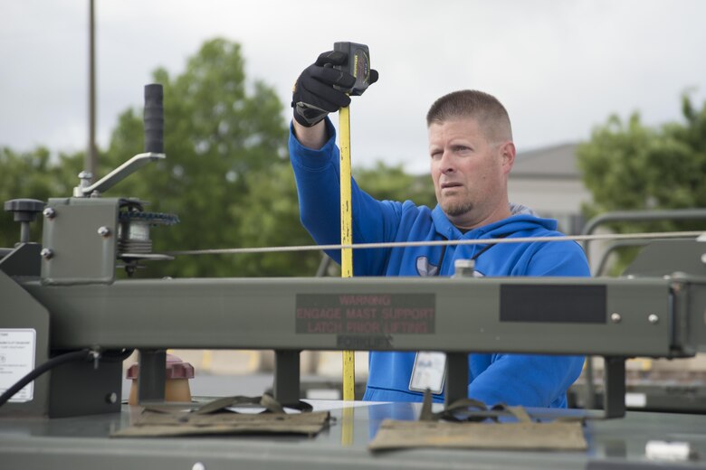 Steven Donigan, 436th Aerial Port Squadron special handler, measures equipment height during the exercise personal deployment function line May 12, 2017, on Dover Air Force Base, Del. Every piece of equipment was weighed and measured to ensure loadmasters have correct information when loading aircraft. (U.S. Air Force photo by Staff Sgt. Jared Duhon)  