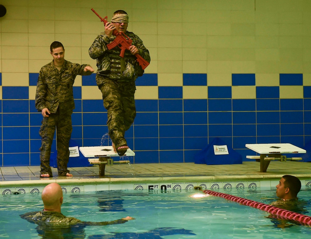 U.S. Air Force Tech. Sgt. Daniel Day, 633rd Security Forces flight chief, conducts water confidence training during a training evaluation at Joint Base Langley-Eustis, Va., April 28, 2017. To accomplish this training evolution, Day had to strip-off his combat vest and recover his weapon after jumping into the Shellbank Fitness Center pool blindfolded. (U.S. Air Force photo/Senior Airman Derek Seifert)
