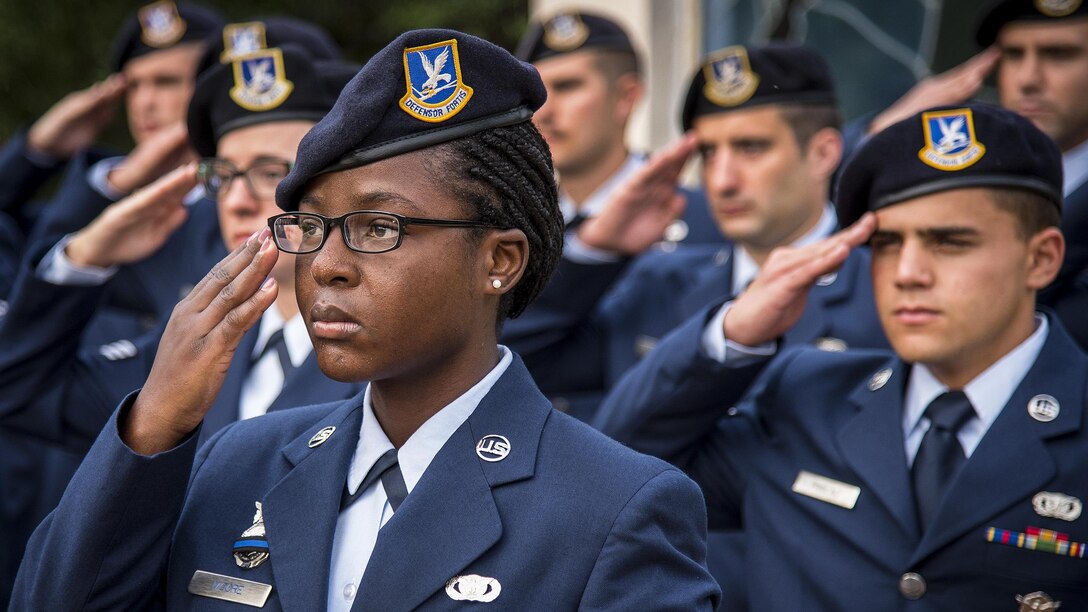 Air Force Senior Airman Delise Moore and fellow airmen salute in formation during the opening ceremony for Police Week at Eglin Air Force Base, Fla., May 15, 2017. Moore is assigned to the 96th Security Forces Squadron. Air Force photo by Samuel King Jr.