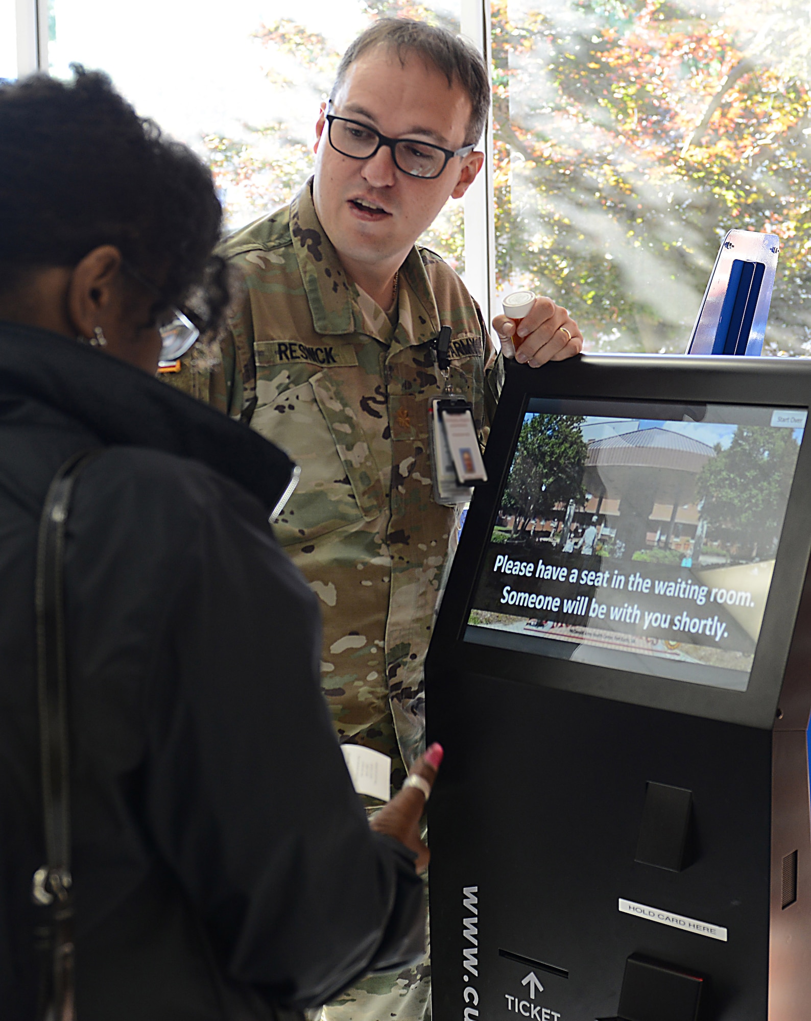 U.S. Army Maj. Adam Resnick, McDonald Army Health Center Department of Pharmacy Service chief, assists a beneficiary while using the queuing system at Joint Base Langley-Eustis, Va., May 9, 2017. The new system allows pharmacy personnel to access a beneficiary’s information quicker, allowing for a shorter wait time. (U.S. Air Force photo/Staff Sgt. Teresa J. Cleveland)