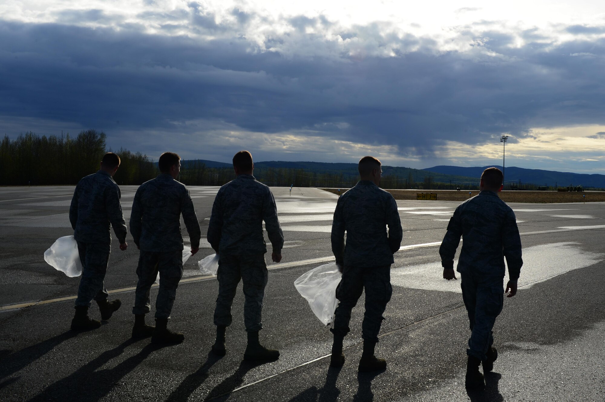 U.S. Air Force Airmen from the 354th Fighter Wing line up to search for foreign object debris (FOD) on the Eielson Air Force Base flightline, May, 15, 2017. The Icemen Team collected a total of 145 pounds of trash and debris. (U.S. Air Force photo by Airman Eric M. Fisher)