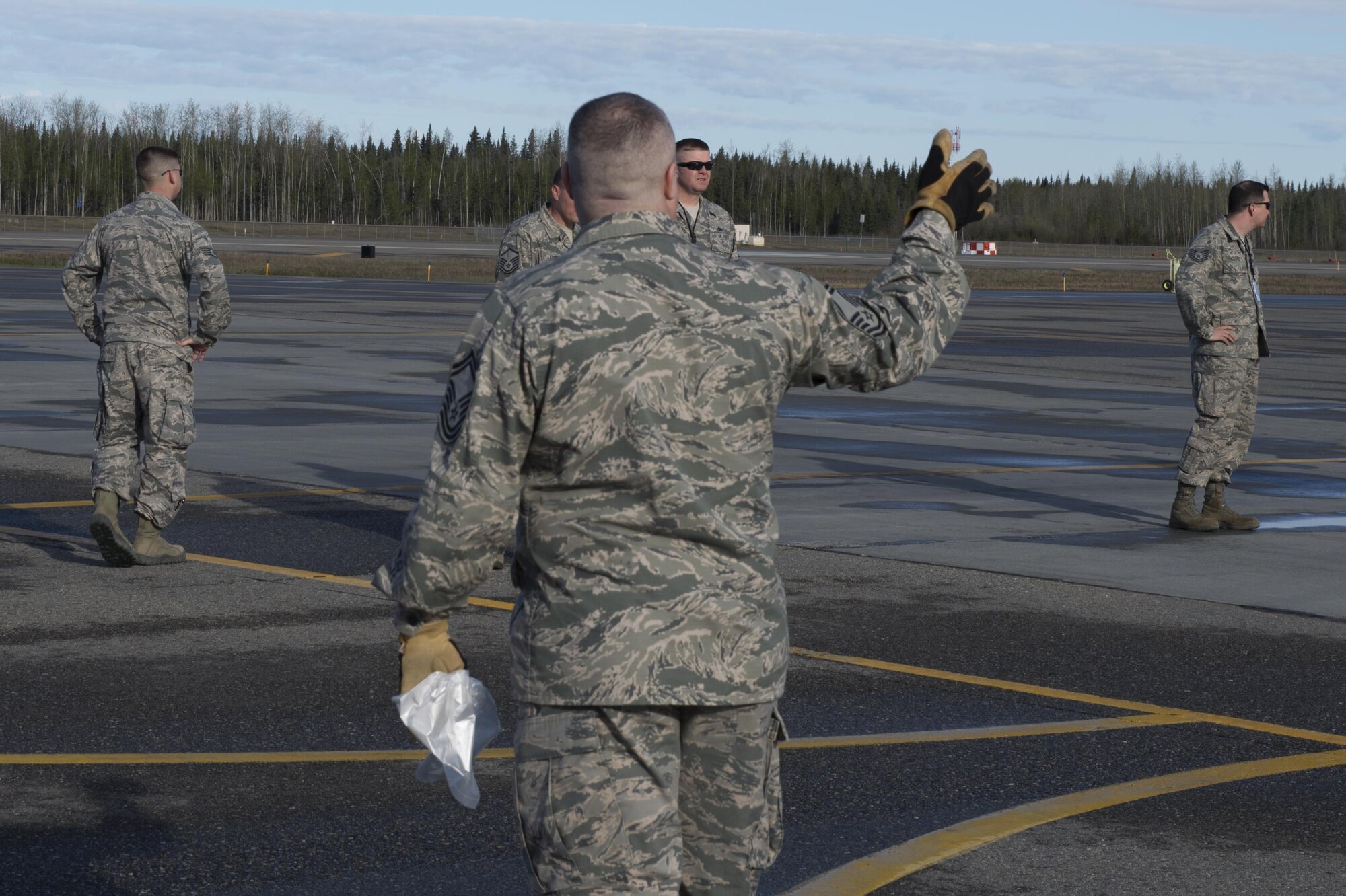 A U.S. Air Force senior master sergeant directs Airmen to line up for a foreign object debris (FOD) walk, May 15, 2017, at Eielson Air Force Base, Alaska. A spring FOD walk is held yearly to ensure Eielson’s flightline is prepared for the upcoming RED FLAG-Alaska season. (U.S. Air Force photo by Airman Eric M. Fisher)