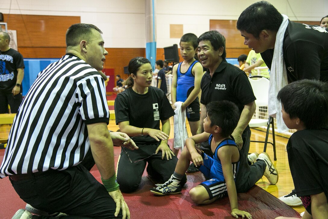 A Marine volunteer explains the rules for the Okinawa Open Championship to Yoshikazu Arakaki May 13 on Marine Corps Air Station Futenma, Okinawa, Japan. The wrestlers practice with two different fighting styles. The Okinawan Youth Wrestling League utilizes freestyle wrestling while the Gladiator Wrestlers utilize folk style. Arakaki is the coach for the Okinawa Youth Wrestling League. (U.S Marine photo by Lance Corporal Tayler P. Schwamb) 