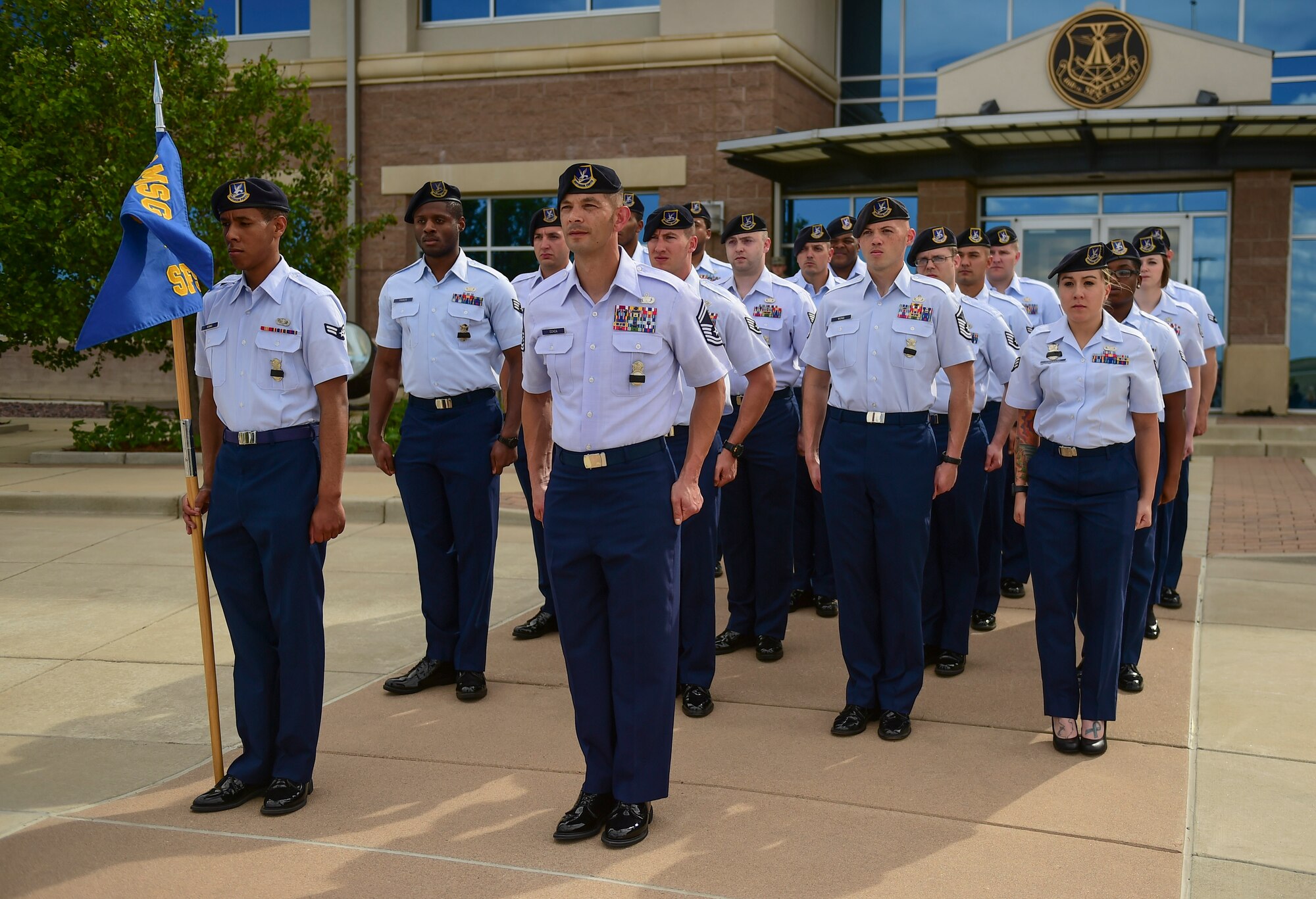 A flight of 460th Security Forces Squadron Airmen stand at attention during a Retreat ceremony May 15, 2017, on Buckley Air Force Base, Colo. The Retreat ceremony recognizes fallen civilian and military law enforcement officers with the 21-gun salute, the playing of TAPS and the National Anthem. (U.S. Air Force photo by Airman Jacob Deatherage/Released)