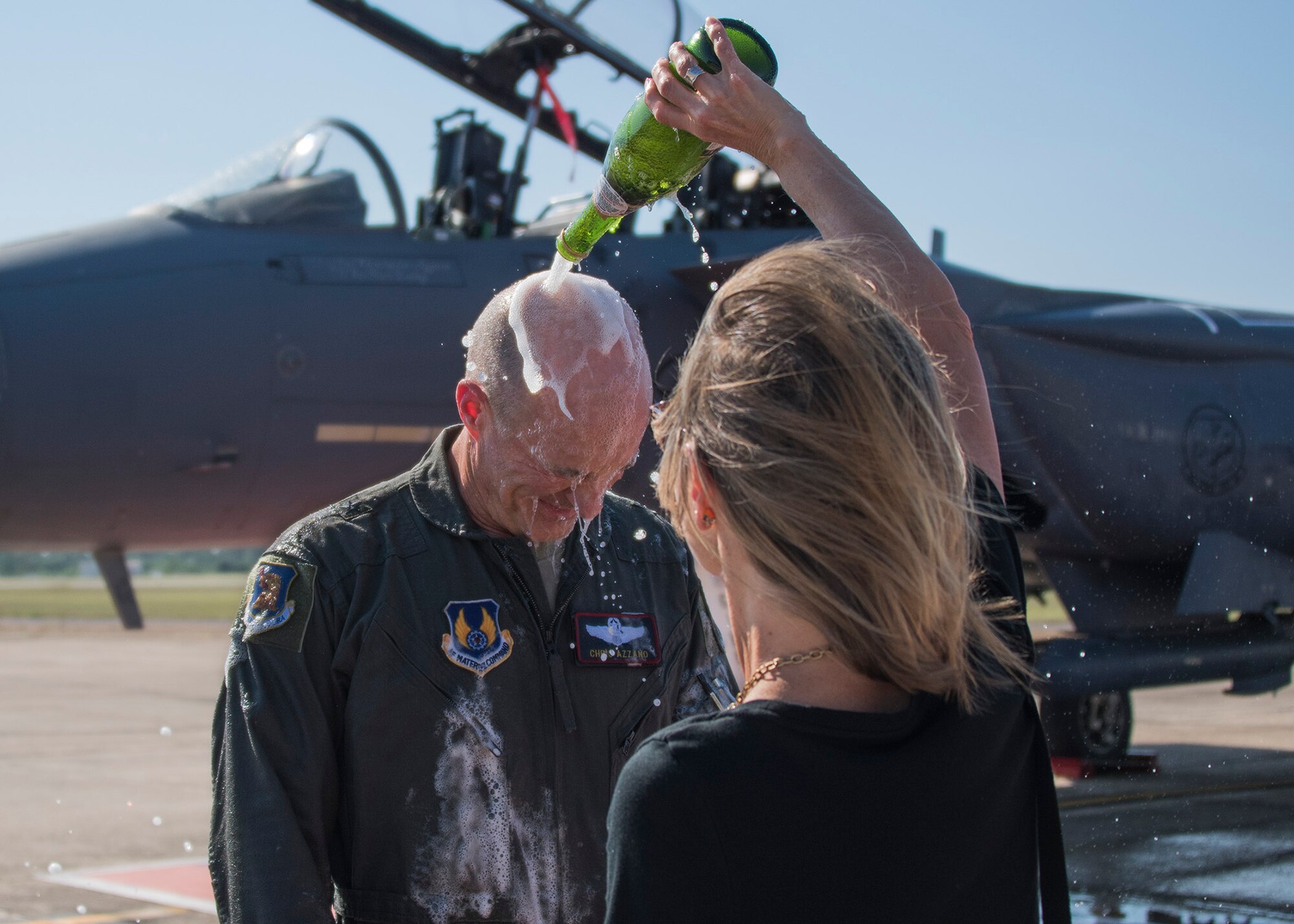Jennifer Azzano, pours a celebratory bottle of champagne on her husband, Brig. Gen. Christopher Azzano, 96th Test Wing commander, during his fini flight at Eglin Air Force Base, Fla. May 15. The fini flight is a symbol of a member’s final flight with the unit or base. Azzano’s new assignment will take him to Wright-Patterson Air Force Base in Ohio to take command of the Directorate of Air, Space and Cyberspace Operations. (U.S. Air Force photo/Ilka Cole) 