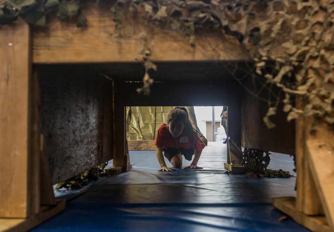 A child with the Young Marines program crawls under an obstacle while attending the Young Marine Battalion Field Meet on Camp Hansen, Okinawa, Japan, May 13, 2017. The field meet allowed local Okinawan children and children of the YMP to overcome obstacles and build camaraderie. (U.S. Marine Corps Photo by Lance Cpl. Deseree Kamm)