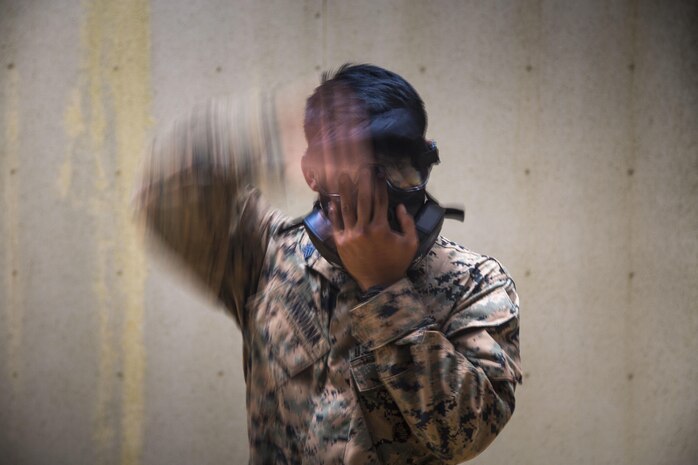 U.S. Marine Sgt. Brent Serquina assigned to 1st Platoon, Bravo Company, 9th Engineer Support Battalion, 3D Marine Logistics Group, puts on his gas mask to prepare for a Military Operation Urban Terrain drill on Camp Hansen, Okinawa, Japan, May 11, 2017. This training was conducted to increase the Marines’ tactical proficiency in a combat environment. (U.S. Marine Corps photo by Lance Cpl. Jesus McCloud)