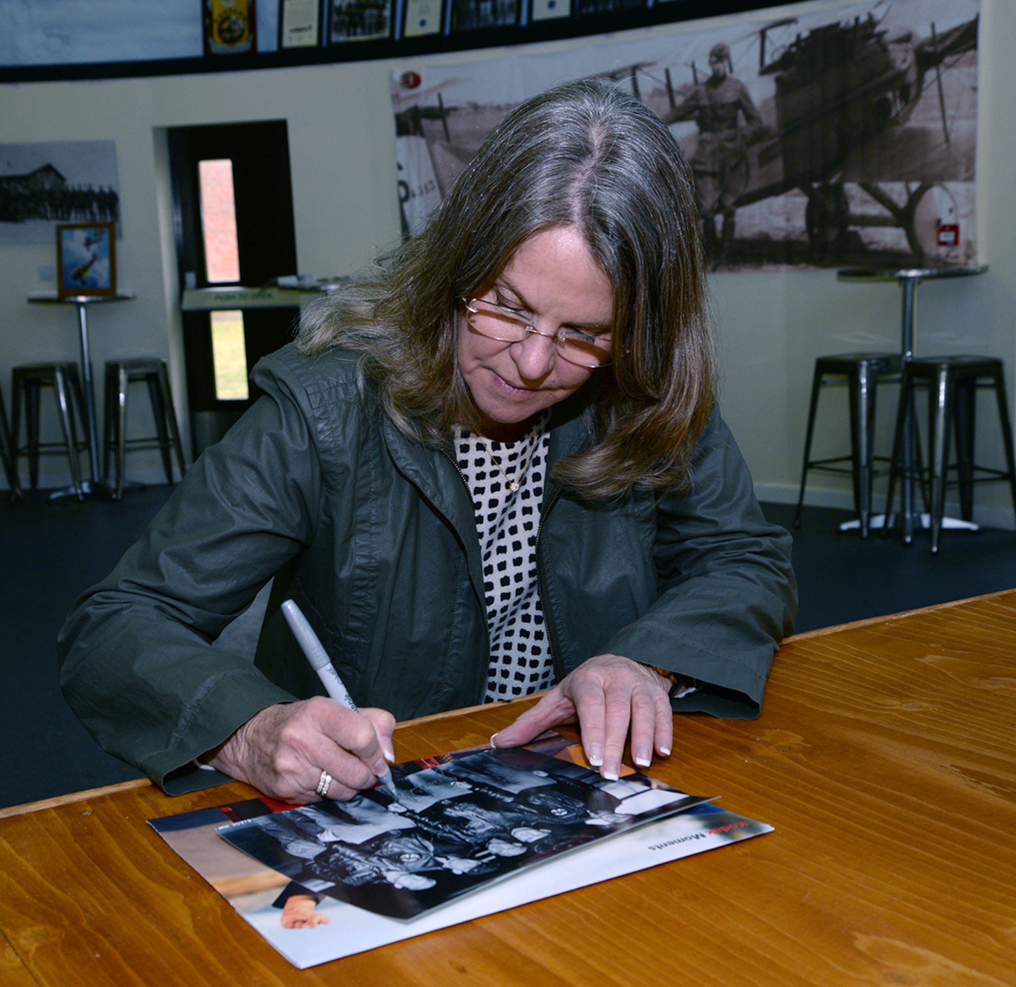 Jonna Doolittle Hoppes, granddaughter of Gen. James Harold “Jimmy” Doolittle, American aviation pioneer and retired lieutenant general in the U.S. Army Air Corps, signs a photo of her grandfather and some of his crew during a visit to the 95th Reconnaissance Squadron Heritage Hub. On April 18, 1942, then-Lt. Col. Doolittle led the daylight air raid on Tokyo after the Japanese attacked Pearl Harbor. His crew on that mission became known as the “Doolittle Raiders.” Hoppes visited RAF Mildenhall along with former World War II bases in East Anglia during the 100th Bomb Group Foundation visit to celebrate the 75th anniversary of the 100th Bomb Group. During World War II, six of the 16 Doolittle Raiders’ crew were from the 95th Bomb Squadron. The 95th BS was redesignated the 95th RS in 1982. (U.S. Air Force photo by Karen Abeyasekere)