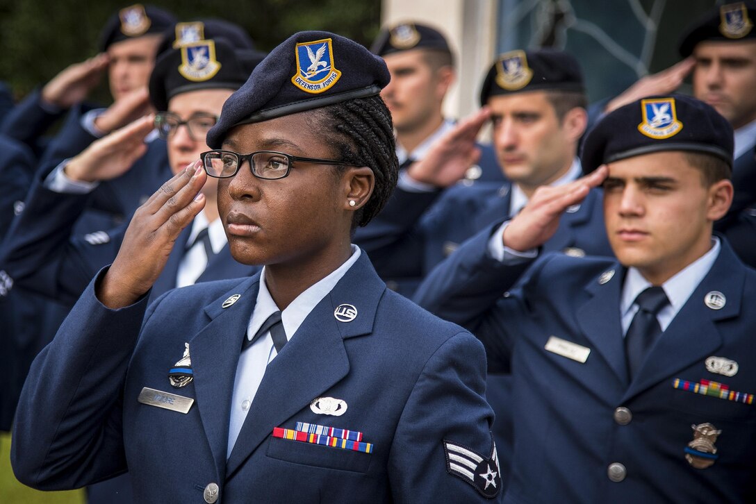 Air Force Senior Airman Delise Moore and fellow airmen salute in formation during the opening ceremony for Police Week at Eglin Air Force Base, Fla., May 15, 2017. Moore is assigned to the 96th Security Forces Squadron. Air Force photo by Samuel King Jr.