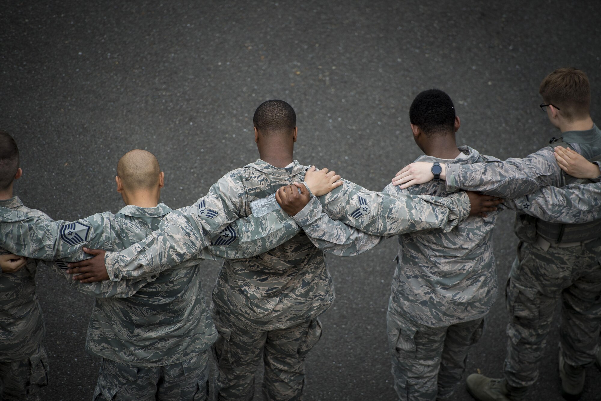 Participants in a Memorial 5K Ruck March join arms during a group prayer, May 15, 2017, at Yokota Air Base, Japan. The Memorial 5K Ruck March concluded with a ceremony that included placing the flag at half mast, prayer and 374th Security Forces Squadron huddle. (U.S. Air Force photo by Airman 1st Class Donald Hudson)