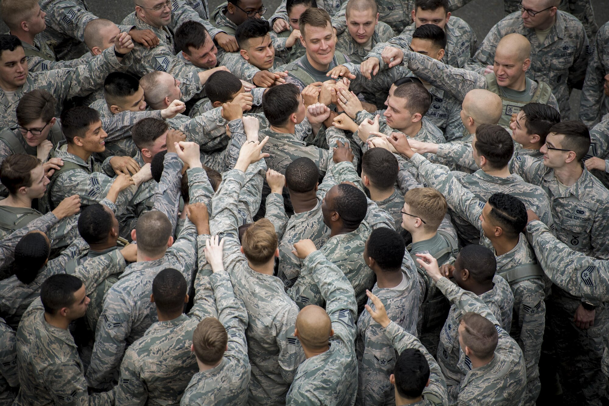 Members of the 374th Security Forces Squadron join in a group huddle, May 15, 2017, at Yokota Air Base, Japan. The Memorial 5K Ruck March concluded with a ceremony that included placing the flag at half mast, prayer and 374th Security Forces Squadron team huddle. (U.S. Air Force photo by Airman 1st Class Donald Hudson)