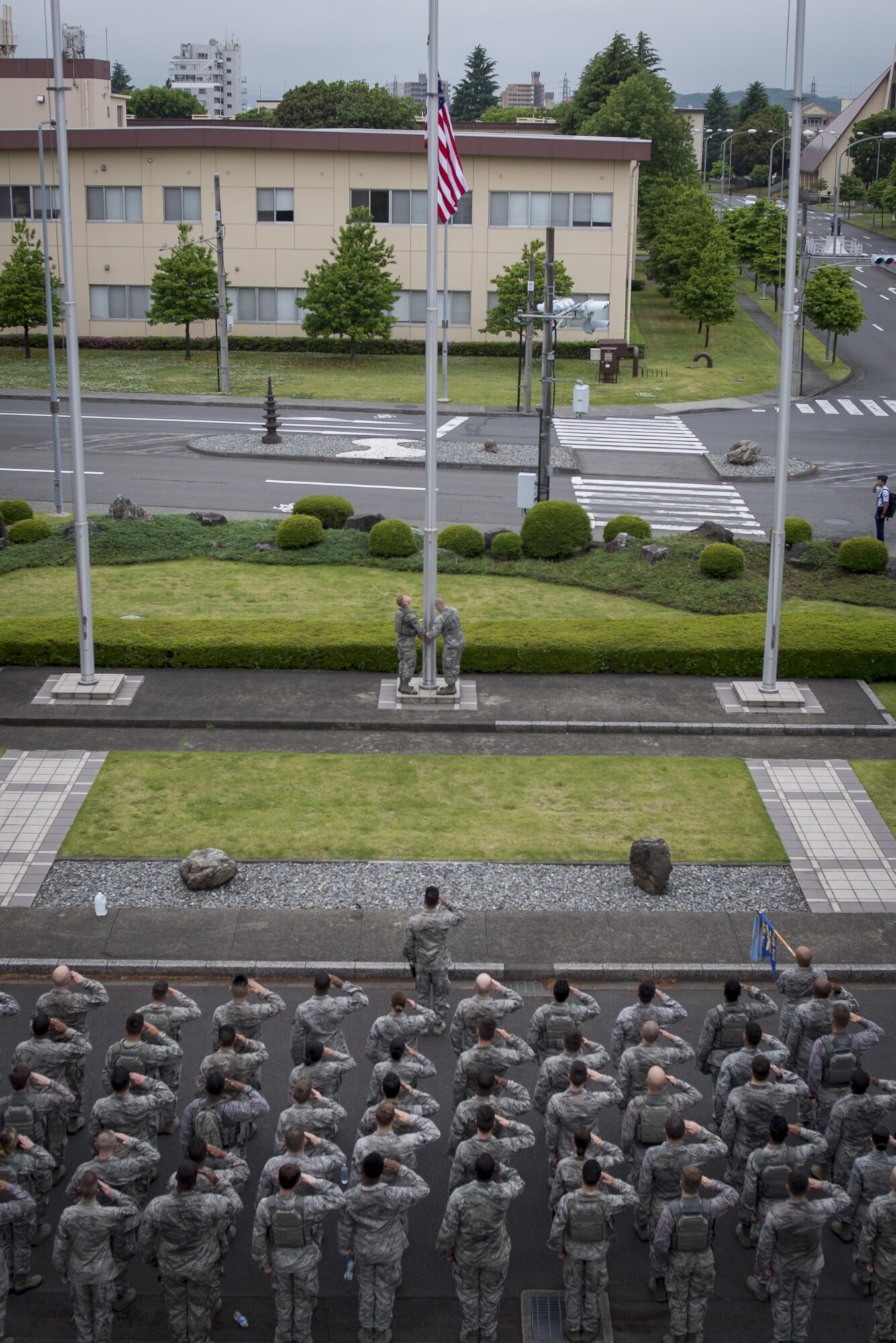 The 374th Security Forces Squadron lowers the flag to half-mast, May 15, 2017, at Yokota Air Base, Japan. The 374th Security Forces Squadron concluded the Memorial 5K Ruck March with the ceremonial lowing of the flag to half-mast; the flag will remain lowered for the duration of Police Week. (U.S. Air Force photo by Airman 1st Class Donald Hudson)
