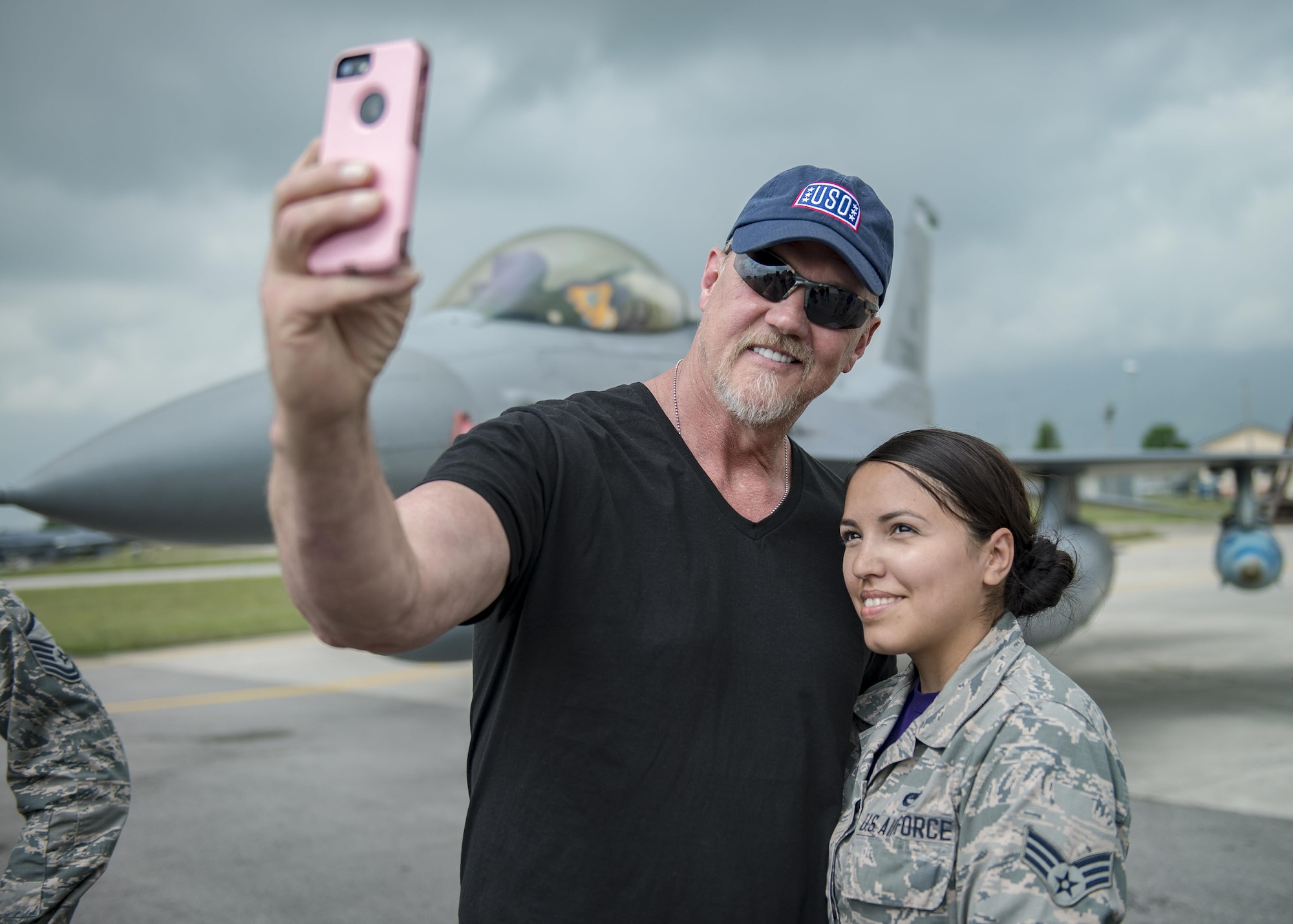 Trace Adkins, country music singer, takes a picture with Senior Airman Elizabeth Sanchez, 31st Aircraft Maintenance Squadron weapons load crew member, during a USO Tour event at Aviano Air Base, Italy, May 12, 2017. Adkins is on his 12th USO tour and performed for service members in Spain and Italy.  (U.S. Air Force photo by Senior Airman Cory W. Bush)
