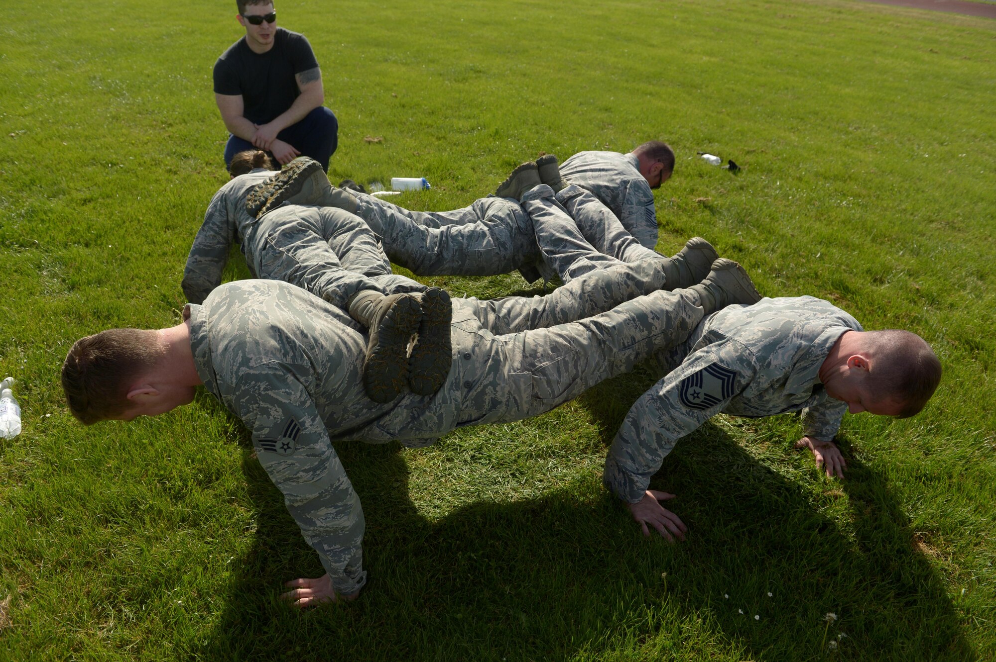 Airmen assigned to the 52nd Security Forces Squadron do team pushups during the Battle of the Badges event for National Police Week at Spangdahlem Air Base, Germany, May 15, 2017. The competition consisted of nine different events. (U.S. Air Force photo by Staff Sgt. Jonathan Snyder)