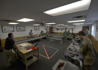 Jeremy Smith, 5th Security Forces Squadron Combat Arms Training and Maintenance instructor, watches Airmen inspect M249 light machine guns at the CATM facility on Minot Air Force Base, N.D., May 8, 2017. Airmen are required to learn proper assembly and disassembly techniques for weapon qualifications. (U.S. Air Force photo/Airman 1st Class Dillon Audit) 