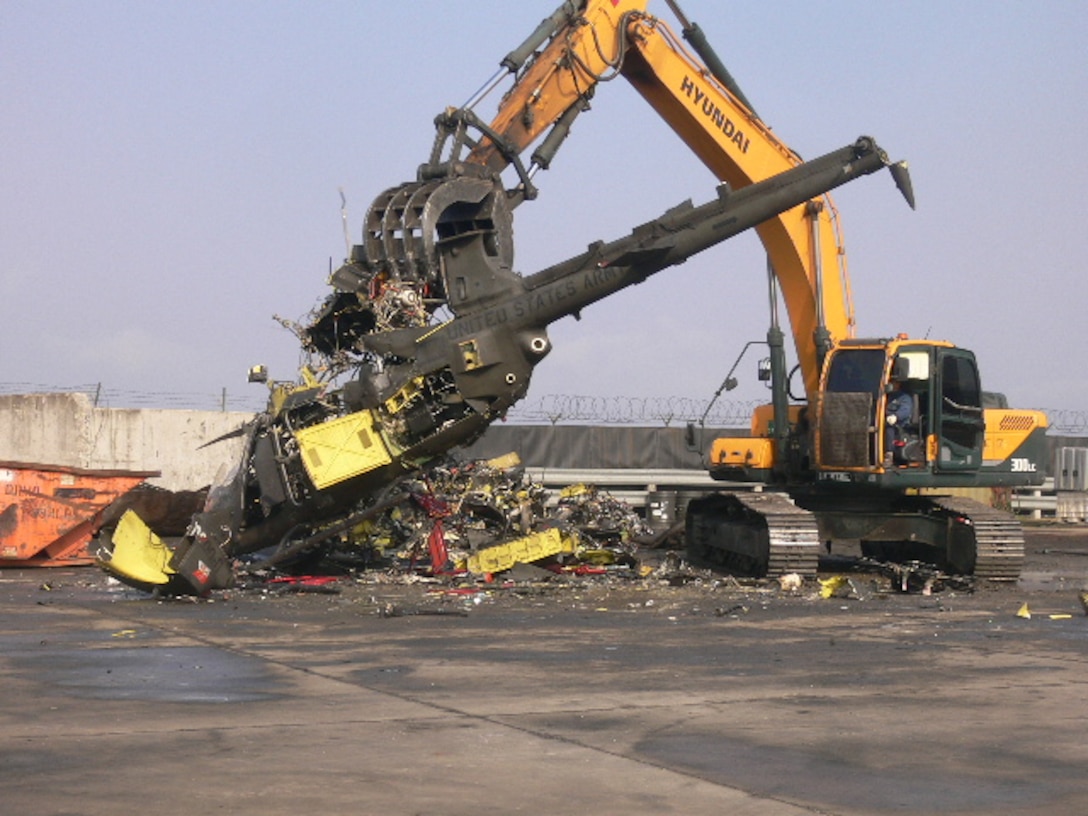 A contractor employs uses an excavator to break up one of 27 OH-58 Kiowa Warrior aircraft at Gimcheon, Korea. 