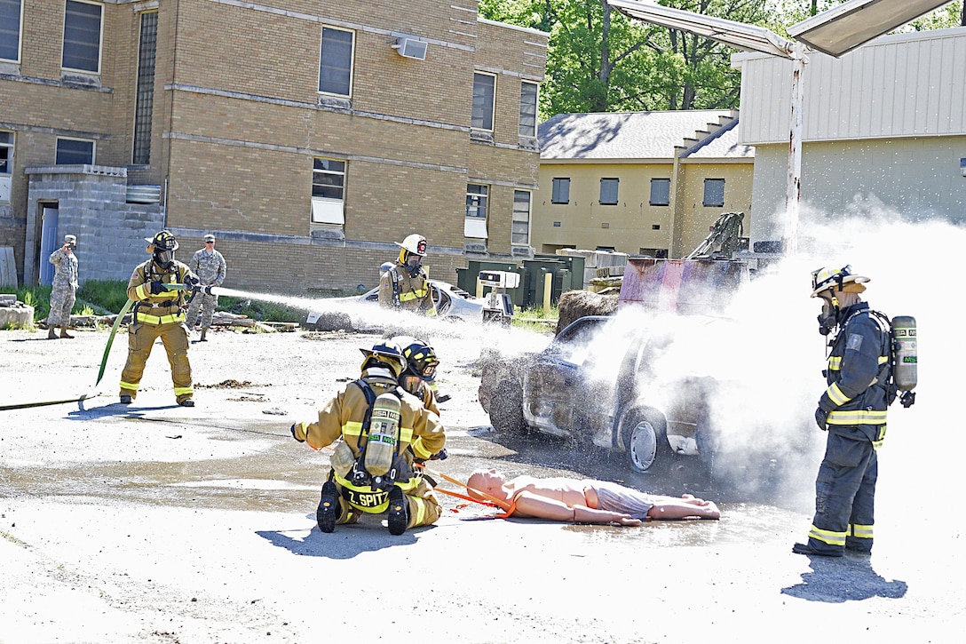 Indiana National Guard firefighters with the 719th Engineer Firefighter Detachment Headquarters, based at Camp Atterbury, Ind., practice extinguishing a car fire and rescuing a mock passenger as part of their training at Muscatatuck Urban Training Center, May 13. (U.S Army Reserve photo by Sgt. Clinton Massey, 206th Broadcasting Operations Detachment)