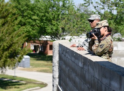 Spc. Roy Lopez with the 206th Broadcast Operations Detachment and Pvt. Justine Gutierrez with the 205th Press Camp Headquarters observe and photograph Indiana National Guard Soldiers at Muscatatuck Urban Training Center on May 13 as part of the U.S. Army Reserve Public Affairs Exercise News Day. (U.S. Army Reserve photo by Sgt. Clinton Massey, 206th Broadcast Operations Detachment)