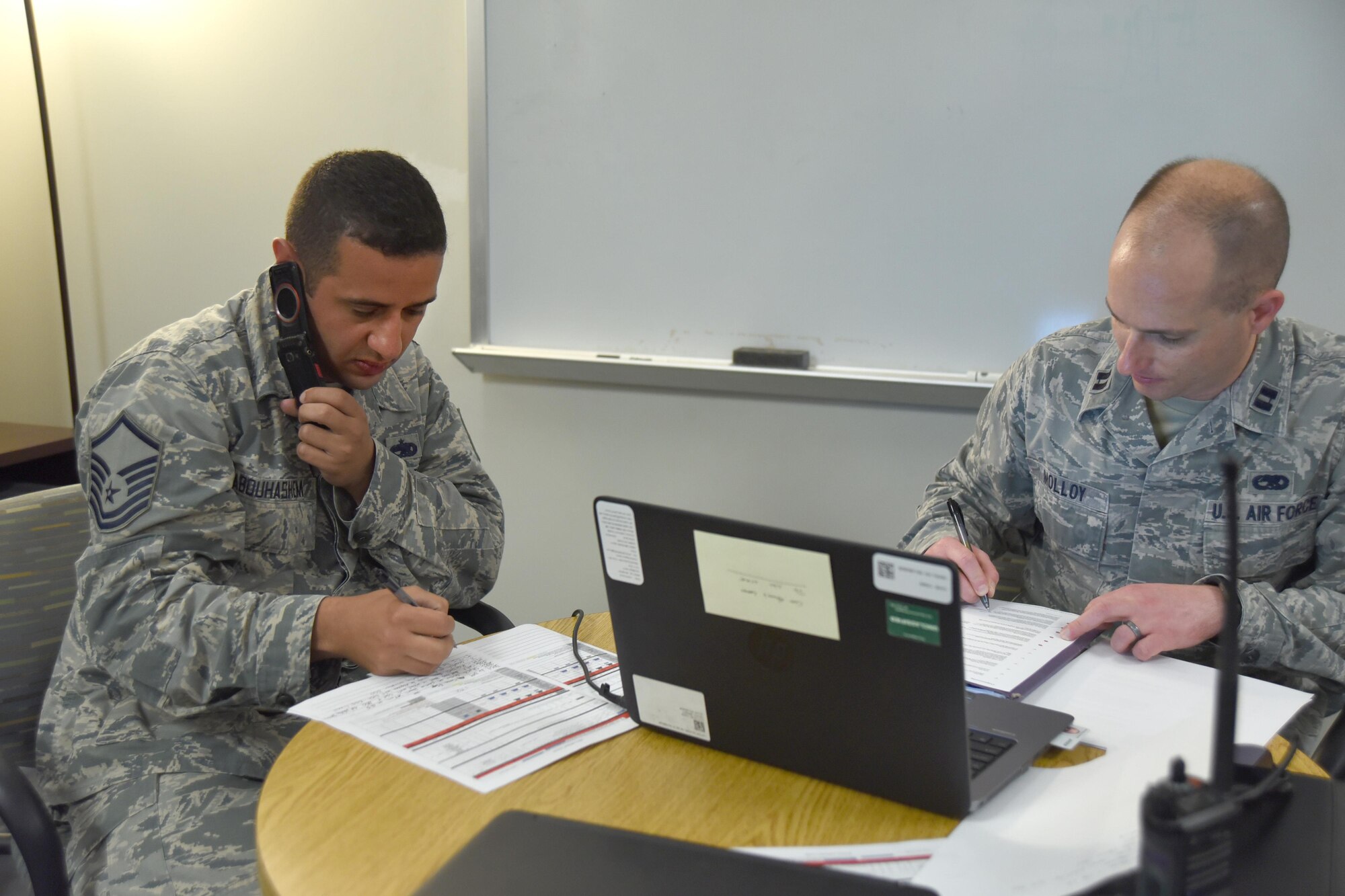 Master Sgt. Mohammed Abouhasem, 22nd Maintenance Squadron production supervisor, left, listens to a phone call during turn over with Capt. Michael Molloy, 22nd MXS operations officer, May 15, 2017, at McConnell Air Force Base, Kan. During turn over, Abouhasem informs Molloy about the status of aircraft. Abouhasem was raised in Doha, Qatar, and has proudly served in the U.S. Air Force for 15 years. (U.S. Air Force photo/Senior Airman Christopher Thornbury)