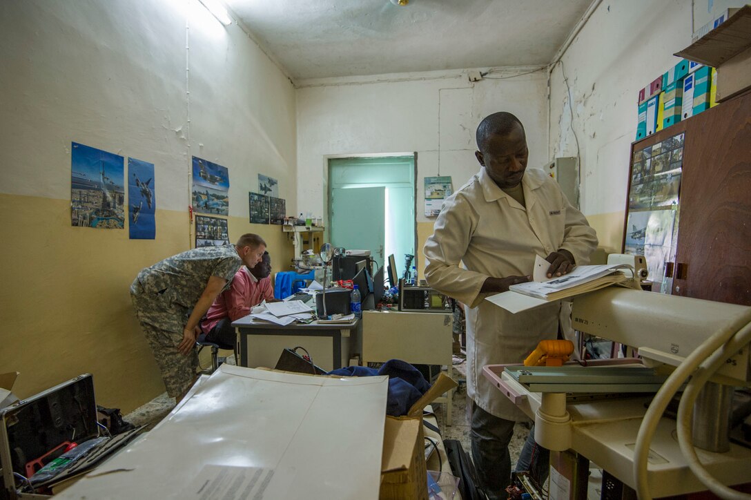 Onesime Kaoueye, chief biomedical technician, and U.S. Army Reserve Chief Warrant Officer 2 Doug Sires, a health services maintenance technician, conduct research while Chadian Lt. Djenaissem Bekoutou, a biomedical technician, reads a manual during Medical Readiness Training Exercise 17-3 at the Military Teaching Hospital in N'Djamena, Chad, May 10. The partnered medical equipment technicians will perform diagnostic tests and repair nonfunctional medical equipment. The mutually beneficial exercise offers opportunities for the partnered militaries to share best practices and improve medical treatment processes. (U.S. Army Africa photo by Staff Sgt. Shejal Pulivarti)