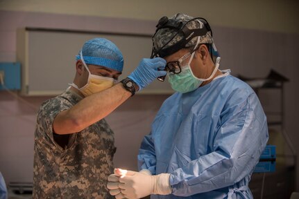 U.S. Army Reserve Sgt. Christopher Mason, a practicing nurse specialist, helps Col. Christopher Sinha, an ear, nose and throat surgeon adjust his headlight prior to a thyroidectomy during Medical Readiness Training Exercise 17-3 at the Military Teaching Hospital in N'Djamena, Chad, May 12. The mutually beneficial exercise offers opportunities for the partnered militaries to share best practices and improve medical treatment processes. (U.S. Army Africa photo by Staff Sgt. Shejal Pulivarti)