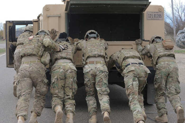 The 91st Security Forces Group Global Strike Challenge team pushes a Humvee at Minot Air Force Base, N.D., May 1, 2017. The team trained in preparation for the upcoming competition, which challenges physical fitness, security forces tactics, job knowledge and weapons firing. (U.S. Air Force photo/Airman 1st Class Jessica Weissman)
