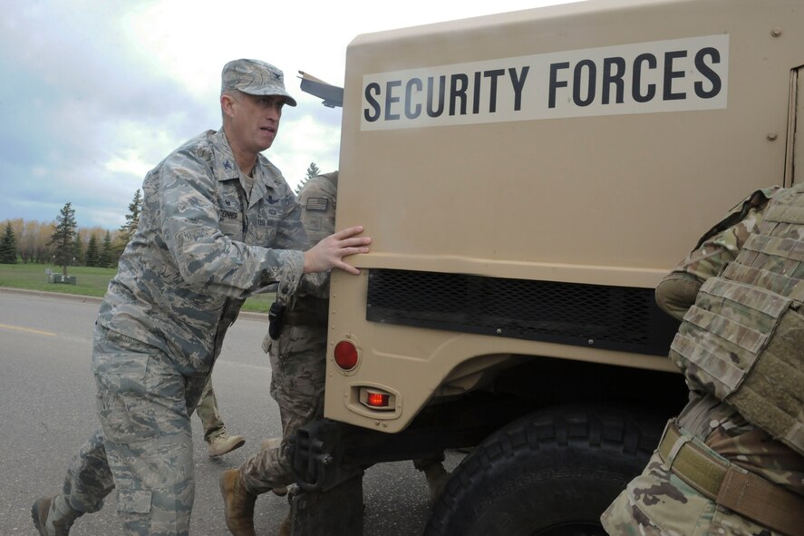 Col. Colin Connor, 91st Missile Wing commander, pushes a Humvee with the 91st Security Forces group Global Strike Challenge team at Minot Air Force Base, N.D., May 1, 2017. The team trained in preparation for the upcoming competition, which challenges physical fitness, security forces tactics, job knowledge and weapons firing. (U.S. Air Force photo/Airman 1st Class Jessica Weissman)