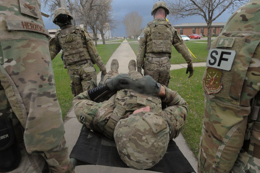 Members of the 91st Security Forces Group Global Strike Challenge team litter-carry a teammate during training at Minot Air Force Base, N.D., May 1, 2017. The team practiced physical fitness with buddy carries, a Humvee push and the litter carry. (U.S. Air Force photo/Airman 1st Class Jessica Weissman)