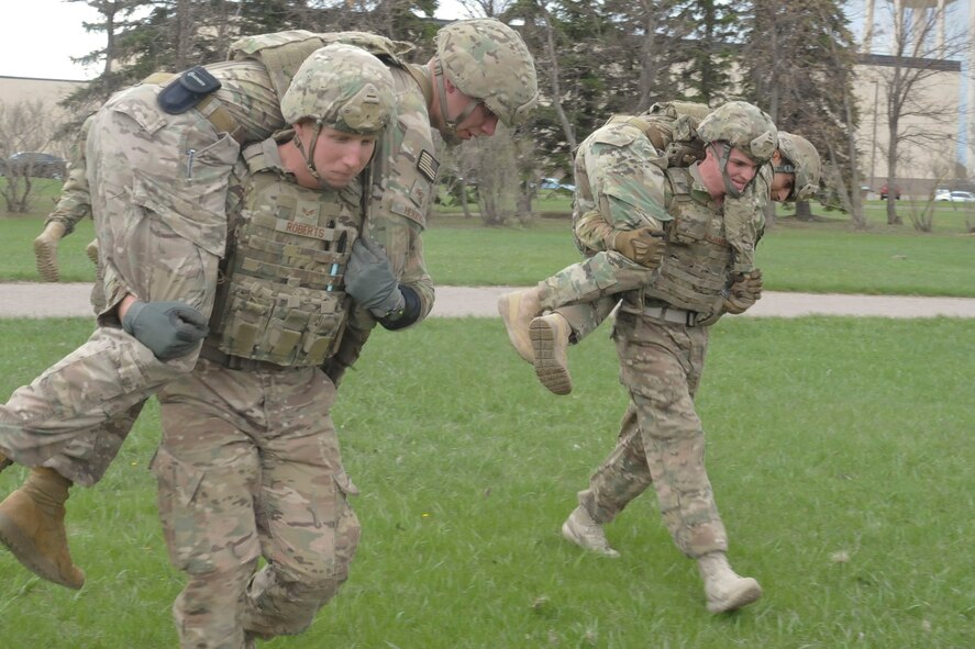 Members of the 91st Security Forces Group Global Strike Challenge team buddy-carry during training at Minot Air Force Base, N.D., May 1, 2017. The team practiced physical fitness with buddy and litter carries, and a Humvee push. (U.S. Air Force photo/Airman 1st Class Jessica Weissman)