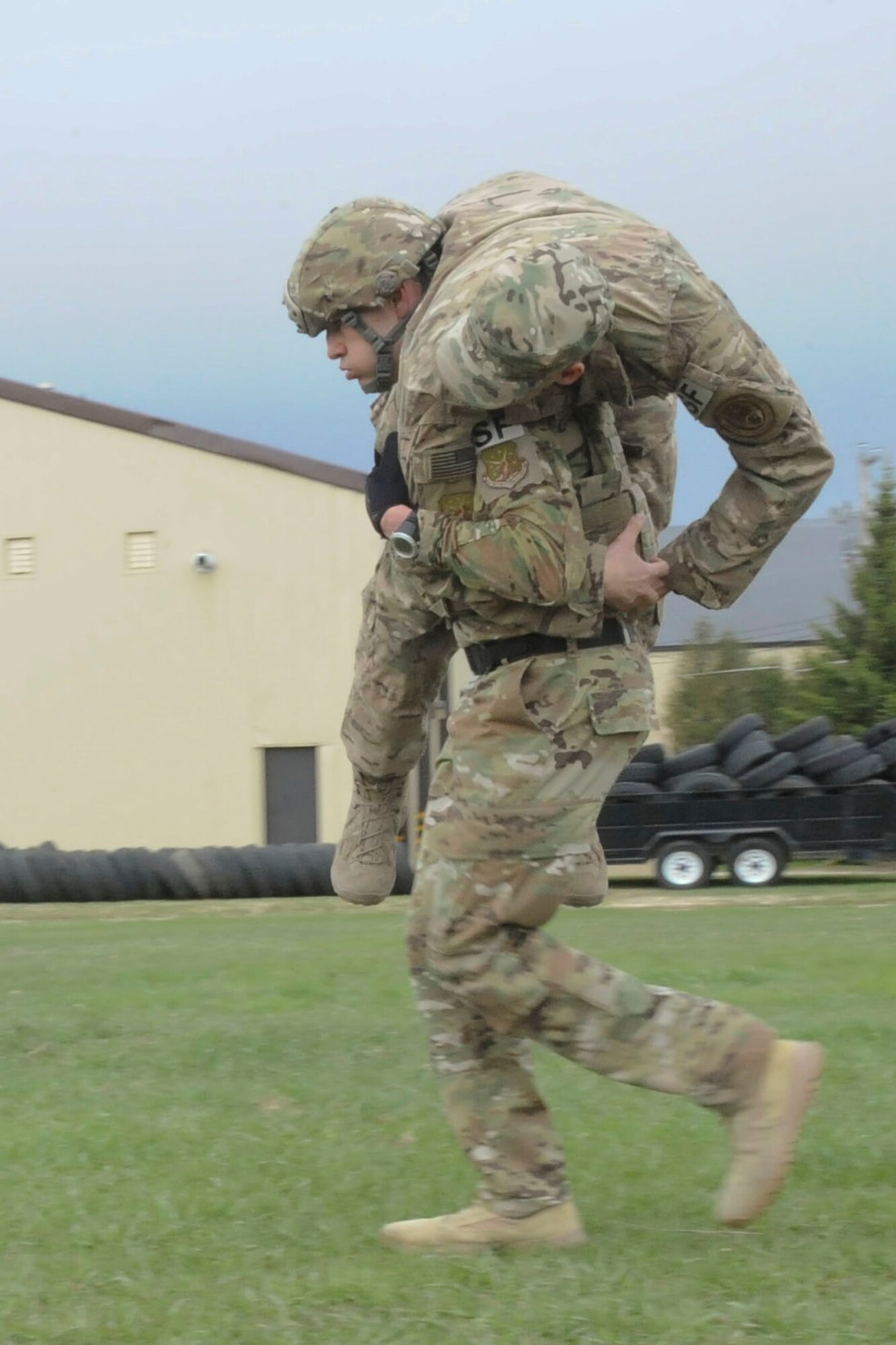 Tech. Sgt. Kyle Douglass, 91st Security Forces Group physical security NCO in charge, buddy carries a teammate during training at Minot Air Force Base, N.D., May 1, 2017. The team practiced physical fitness with buddy carries, a Humvee push and a liter carry. (U.S. Air Force photo/Airman 1st Class Jessica Weissman)