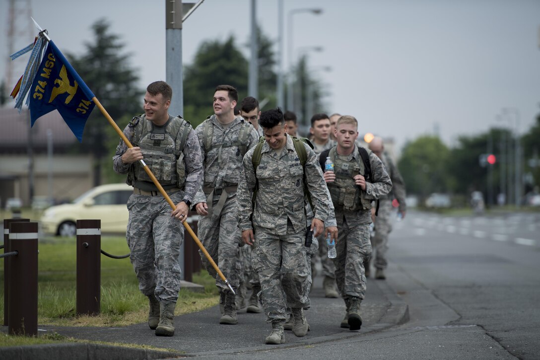 Participants in the Memorial 5K Ruck March lead the formation with the 374th Security Forces Squadron flag, May 15, 2017, at Yokota Air Base, Japan. The Memorial 5K Ruck March had approximately 75 participants from the 374 SFS, Office of Special Investigations and various members of base leadership. (U.S. Air Force photo by Airman 1st Class Donald Hudson)