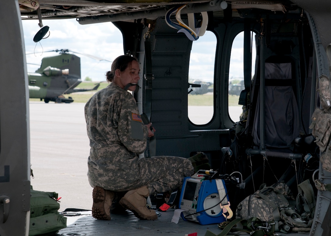 Sgt. Rebecca Himmel, a medic attached to the 1-169th Aviation Regiment, readies medical equipment and her personal gear aboard a Blackhawk helicopter prior to performing a joint medevac training mission during Exercise Maple Resolve 17 at Camp Wainwright, Alberta, May 16, 2017. Exercise Maple Resolve is an annual collective training event designed for any  contigency operation. Approximately 4,000 Canadian and 1,000 U.S. troops are participating in Exercise Maple Resolve 17.