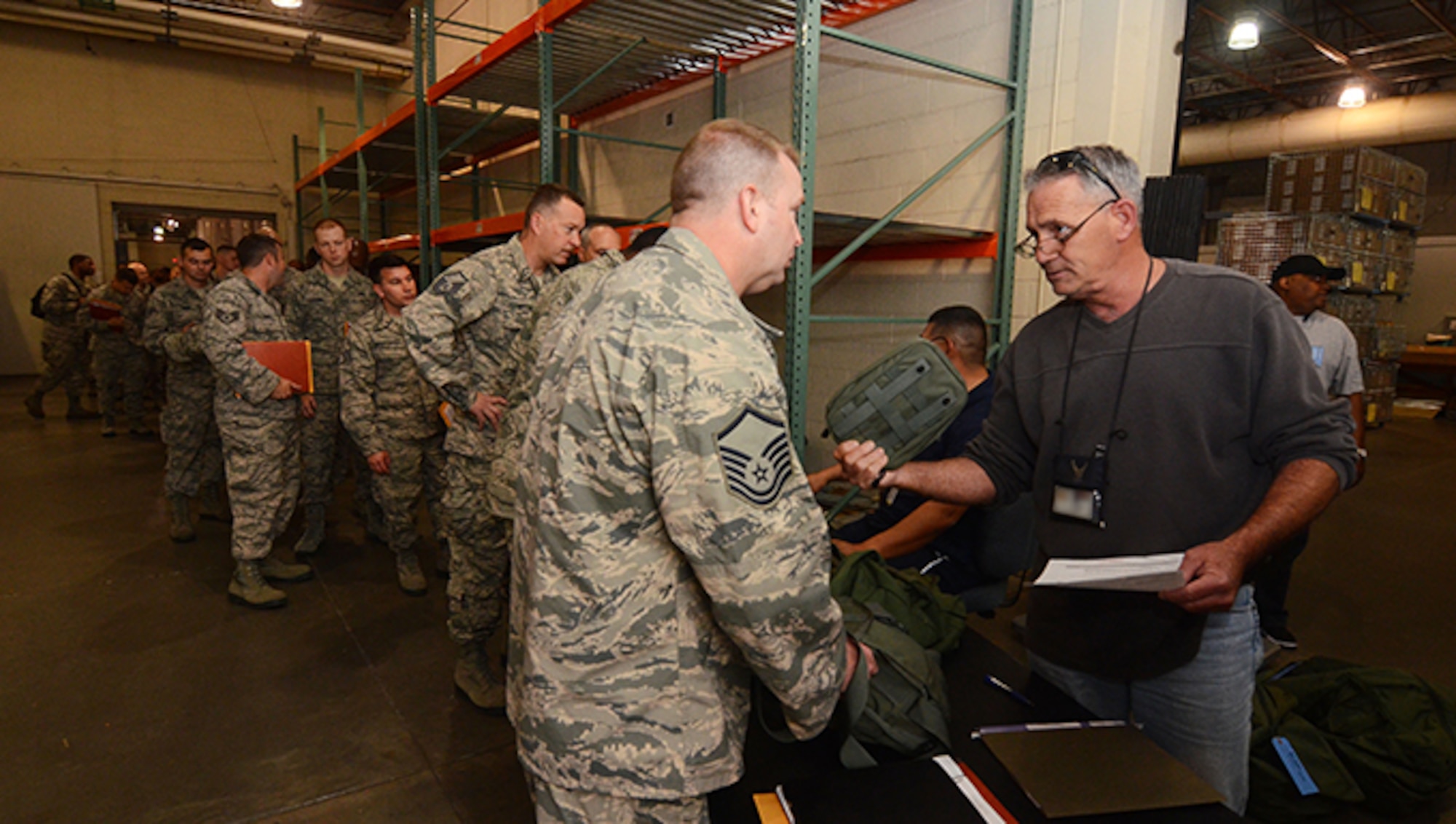 Mark Young, 94th Logistics Readiness Squadron supply and fuels coordinator, issues a mobility bag item to an Airman at Dobbins Air Reserve Base, Georgia. May 5, 2017. Thanks to a new streamlined process for issuing these items, LRS is able to process deployers much faster, said Young. (U.S. Air Force photo/Don Peek)