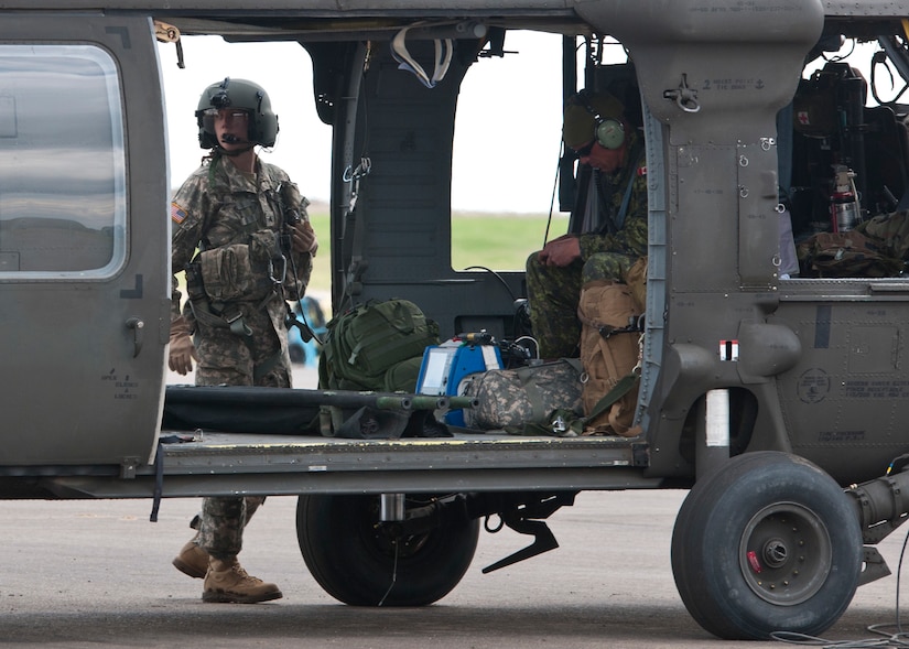 Sgt. Rebecca Himmel, a medic attached to the 1-169th Aviation Regiment, and Canadian Cpl. Jason Flegel, a forward aeromedevac specialist with the 2nd Field Ambulance, prepare to embark on a joint medevac training mission during Exercise Maple Resolve 17 at Camp Wainwright, Alberta, May 16, 2017. Exercise Maple Resolve is an annual collective training event designed for any  contigency operation. Approximately 4,000 Canadian and 1,000 U.S. troops are participating in Exercise Maple Resolve 17.