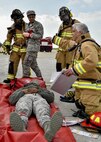 Joseph Cavalero (right), a firefighter with the 910th Civil Engineer Fire Department here, instructs his team members on treatment for Airman Garri Johnson, a personnel helper with the 910th Mission Support Squadron, who is simulating an accident victim during a Major Accident Response Exercise (MARE), May 16, 2017. Exercise organizers use moulage, cosmetics intended to simulate injuries, to enhance the realism of the scenario. The purpose of the exercise, conducted by the Wing Inspection Team and Emergency Management office, was to document response capabilities of installation personnel while honing joint response practices with local agencies including local law enforcement and the American Red Cross. (U.S. Air Force photo/Eric White)