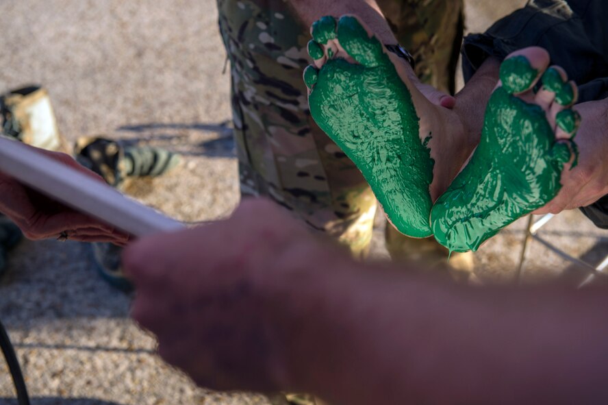 Col. Mark Barrera, 23d Wing vice commander, prepares to imprint his feet on a tile, paying tribute to Moody’s 347th Rescue Group, as a part of his fini flight from Moody Air Force Base, Ga., May 15, 2017. Upon completion of their final flights, military aviators are hosed down with water by their comrades, family, and friends before they depart their squadron. Barrera will continue his Air Force career by attending the Joint Military Attaché School to become an Air Attaché in Italy. During this tenure, he will act as an embassy liaison with host-nation defense establishments, openly observe and report developments and significant events, and actively participate in national security and operational policy development and coordination. (U.S. Air Force photo by Senior Airman Greg Nash)