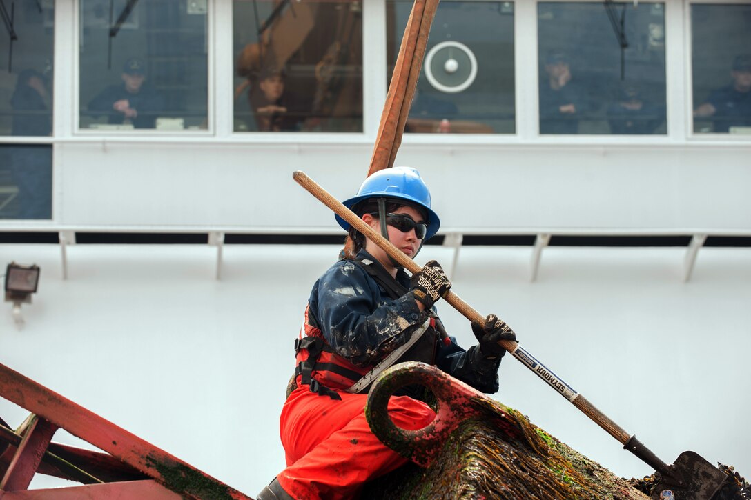 Coast Guard Cutter Oak crew member Seaman Samantha Schwind scrapes mussels and other marine growth off a buoy near the coast of Nantucket, Mass., May 10, 2017. The Cutter Oak is a 225-foot buoy tender homeported in Newport, Rhode Island. Coast Guard photo by Petty Officer Andrew Barresi
