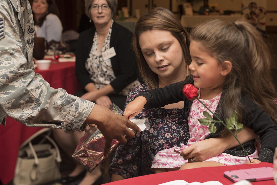 Alexea Reano, right, military child, and Theresa Nedrow, military spouse, reach for raffle tickets during the Military Spouse Appreciation Luncheon inside The Club at Joint Base Andrews, Md., May 12, 2017. Prizes such as gift cards, flowers and gift baskets were given out to those with winning tickets. (U.S. Air Force photo by Senior Airman Philip Bryant) 