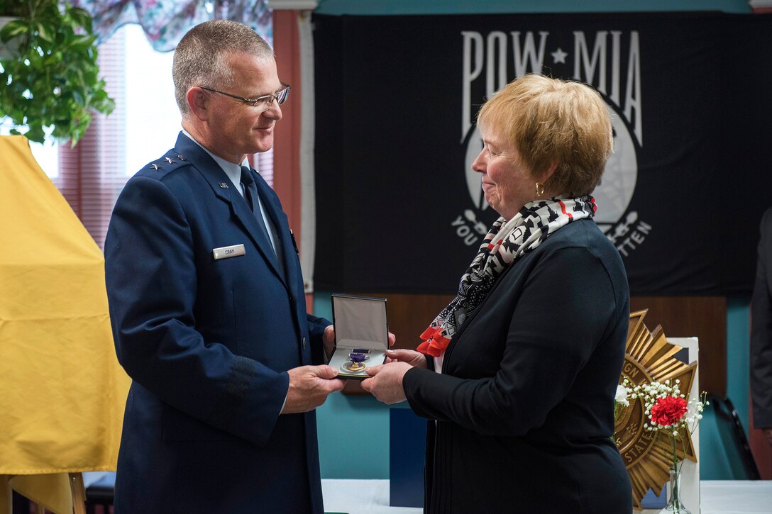 Air Force Maj. Gen. Steven Cray, adjutant general of the Vermont National Guard, presents Karen O’Brien with a Purple Heart Medal during a memorial ceremony for her uncle, Army Cpl. George A. Perreault, at the Veterans of Foreign Wars Post 1767, Winooski, Vt., May 13, 2017. Perreault, who was reported missing in action on February 13, 1951, during the Korean War, was recently identified and returned to his family for burial with full military honors. Air National Guard photo by Tech. Sgt. Sarah Mattison