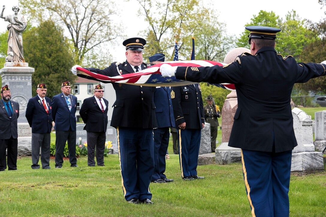 Vermont Army National Guard Master Sgt. Daniel Landry, left, and Vermont Army National Guard Sgt. John Curtis fold the U.S. flag during the funeral of Army Cpl. George A. Perreault at Saint Francis Xavier Cemetery, Winooski, Vt., May 13, 2017. Air National Guard photo by Tech. Sgt. Sarah Mattison