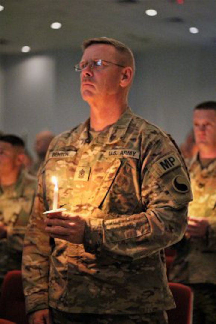 Sgt. Maj. Michael Benton stands tall holding a candle to honor those who gave the ultimate sacrifice in the line of duty during a  vigil held on Camp Arifjan, Kuwait, May 5, 2017.