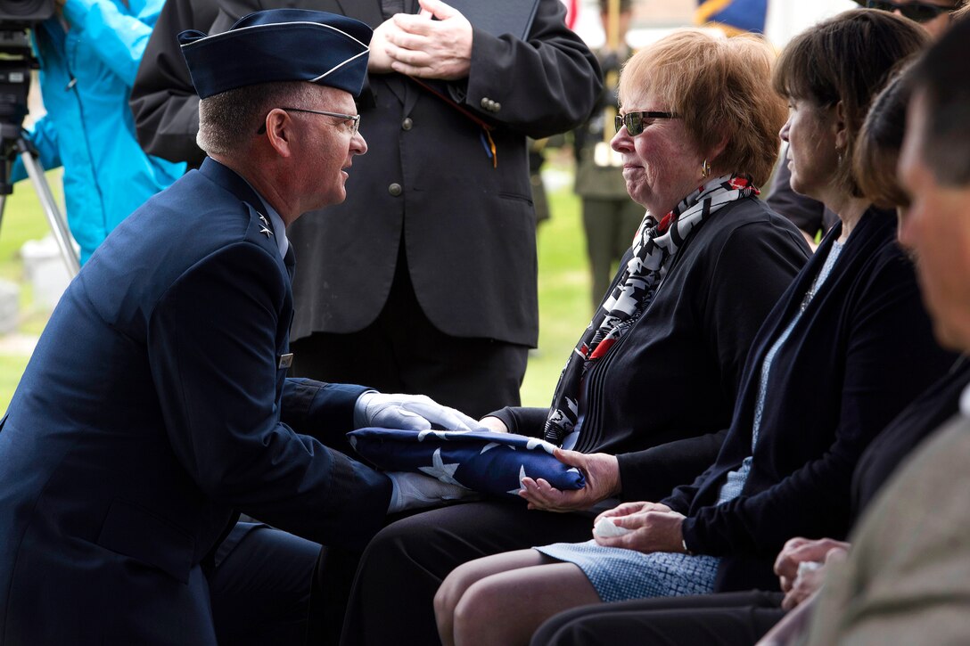 Air Force Maj. Gen. Steven Cray, left, adjutant general of the Vermont National Guard, presents Karen O’Brien with the American flag during the funeral for her uncle, Army Cpl. George A. Perreault, at Saint Francis Xavier Cemetery, Winooski, Vt., May 13, 2017. Air National Guard photo by Tech. Sgt. Sarah Mattison