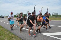 Marines, Sailors and Midshipmen from Auburn University make their way past the entrance to Duke Field, Fla. May 9 during their recent 201-mile journey from their campus headquarters to the Black Hawk memorial in Navarre, Fla.  The ruck marchers made the trip to honor the memory of Raider 7, an elite group of Marine Raiders who perished in a helicopter training accident in Navarre March 10, 2015.  (U.S. Air Force photo/Dan Neely)