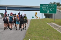 Marines, Sailors and Midshipmen from Auburn University make their way past the entrance to Duke Field, Fla. May 9 during their recent 201-mile journey from their campus headquarters to the Black Hawk memorial in Navarre, Fla.  The ruck marchers made the trip to honor the memory of Raider 7, an elite group of Marine Raiders who perished in a helicopter training accident in Navarre March 10, 2015.  (U.S. Air Force photo/Dan Neely)