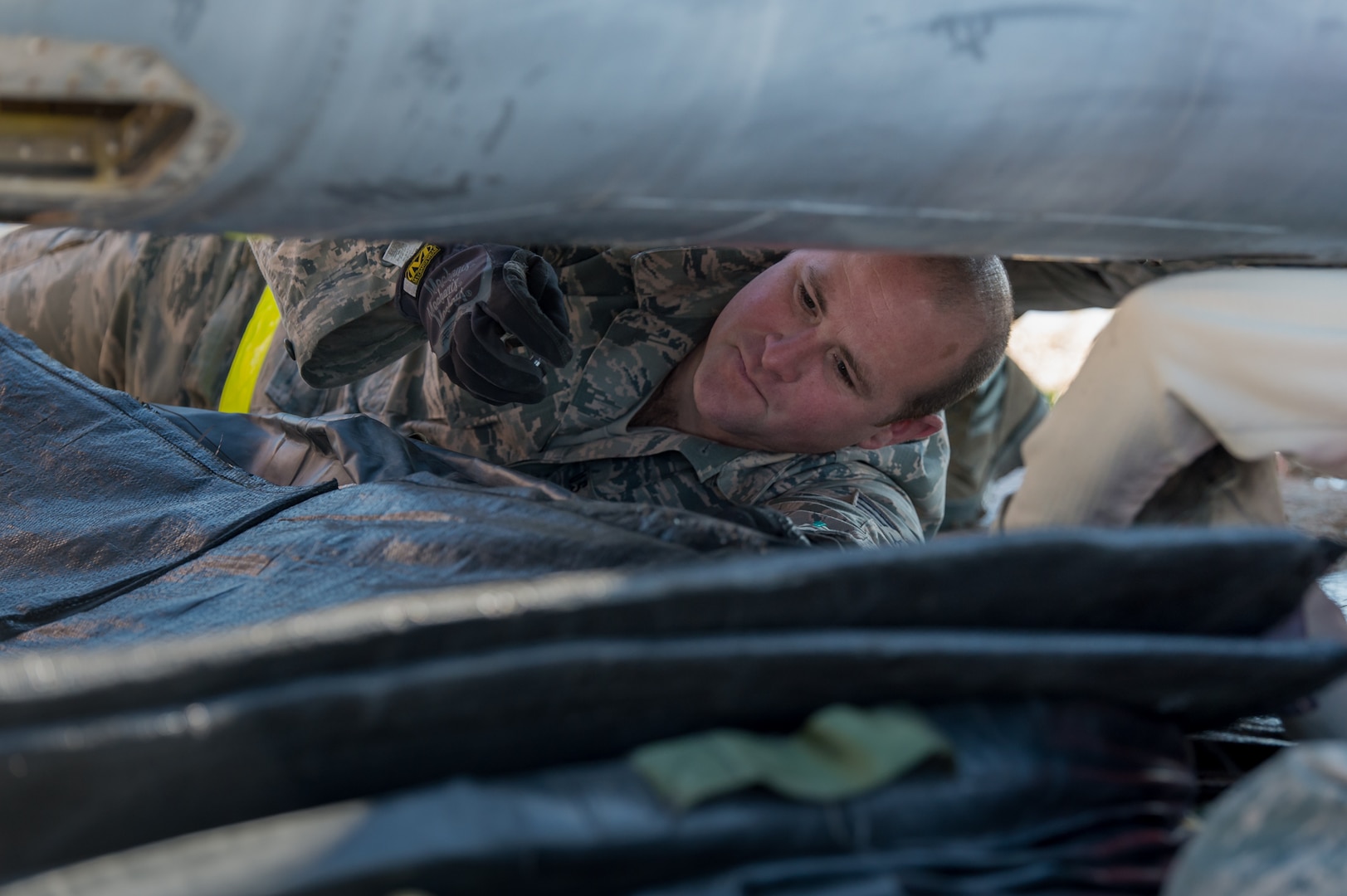 U.S. Air Force Tech. Sgt. Jeremy Mullin, aircraft fuel system specialist with the 153rd Maintenance Group's Crash Damage or Disabled Aircraft Recovery team configures an air bag for inflation prior to jacking an A-7 Corsair II aircraft, May 11, 2017 in Cheyenne, Wyoming. Maintainers from all aircraft specialties practiced moving a fighter aircraft from the mud into a parking spot as part of an annual CDDAR requirement. (U.S. Air National Guard photo by Senior Master Sgt. Charles Delano/released)