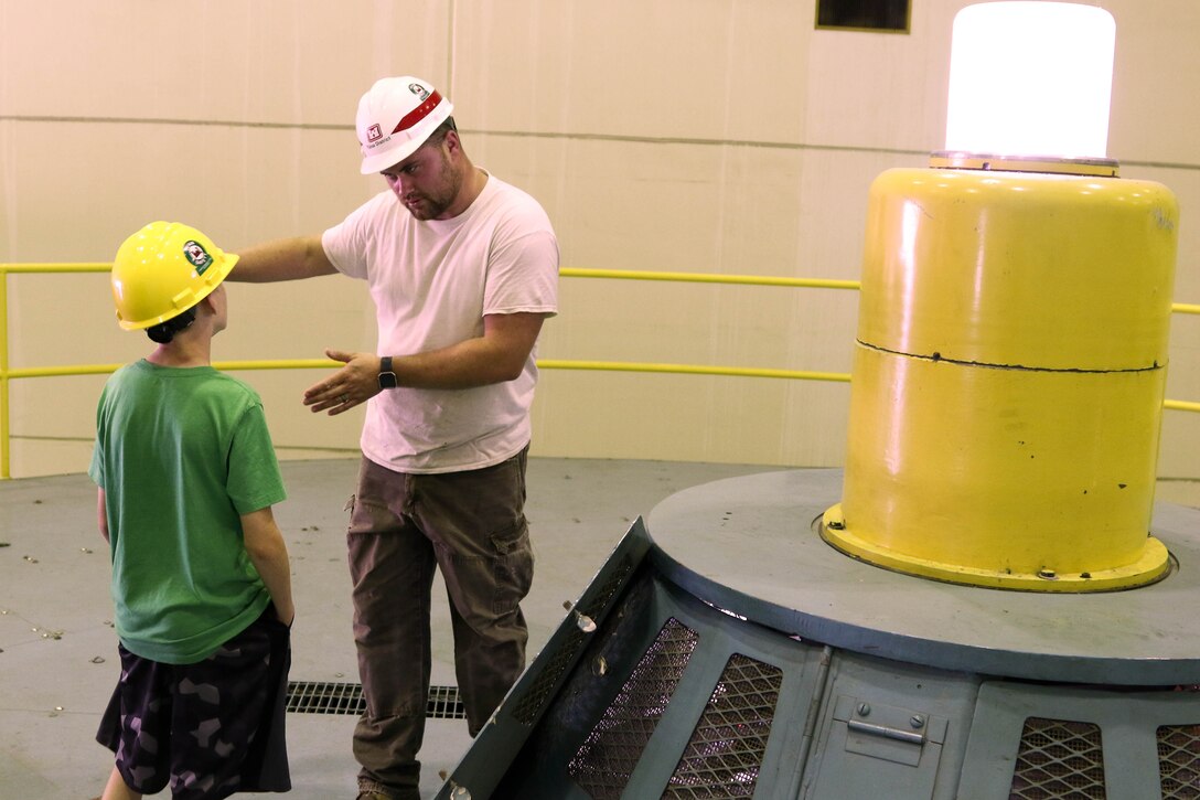 Walyn Hensley (right) explains the inner workings of a powerhouse to Lydon Swafford May 12.  Lydon won the Mannford Middle School science fair with a project on hydropower and was given a tour of Keystone dam for his efforts.