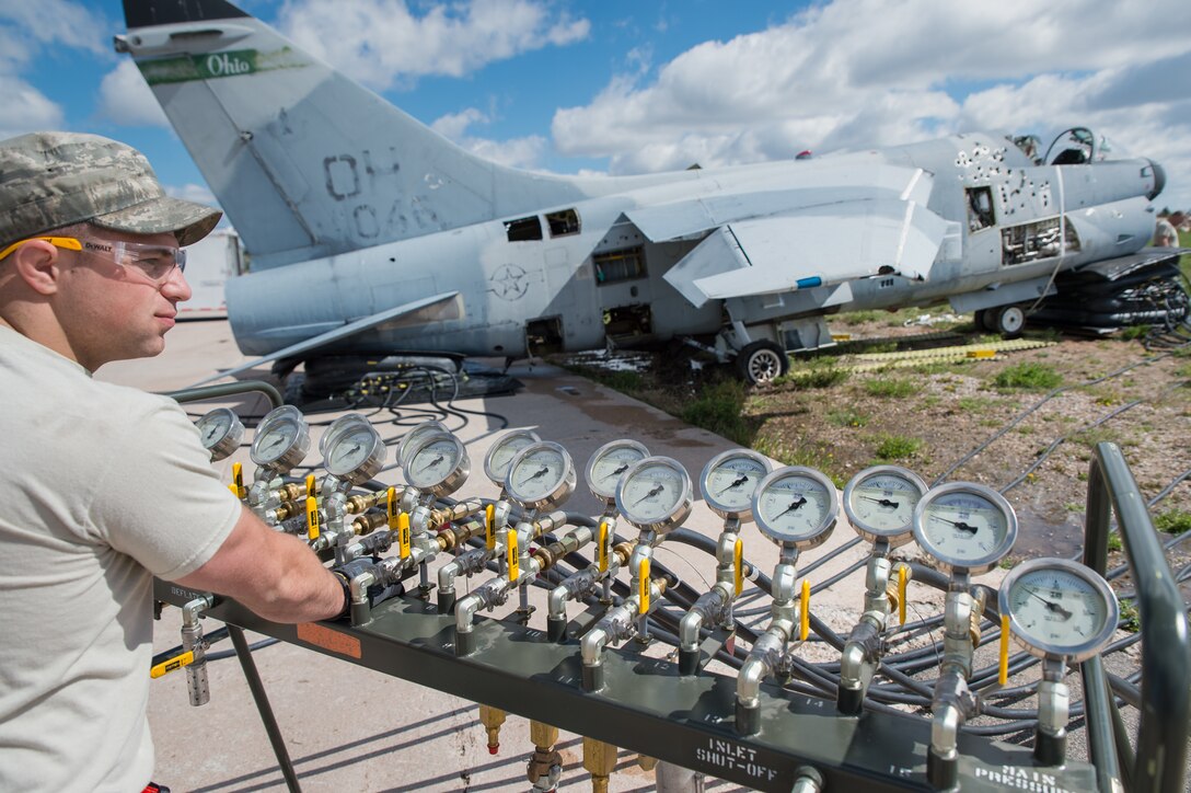 U.S. Air Force Senior Airman Dakota Difrancesco with the 153rd Maintenance Group's Crash Damage or Disabled Aircraft Recovery team monitors a manifold during the jacking of an A-7 Corsair II aircraft, May 11, 2017 in Cheyenne, Wyoming. Maintainers from all aircraft specialties practiced moving a fighter aircraft from the mud into a parking spot as part of an annual CDDAR requirement. (U.S. Air National Guard photo by Senior Master Sgt. Charles Delano/released)