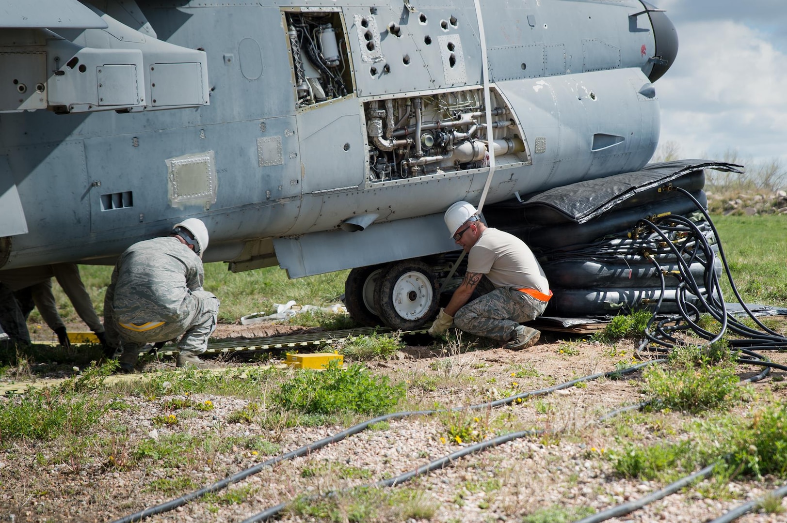 U.S. Air Force Tech. Sgt. Sean Quinlan and Staff Sgt. Aaron Berning with the 153rd Maintenance Group's Crash Damage or Disabled Aircraft Recovery team place steel planking beneath the front landing gear of an A-7 Corsair II aircraft, May 11, 2017 in Cheyenne, Wyoming. Maintainers from all aircraft specialties practiced moving a fighter aircraft from the mud into a parking spot as part of an annual CDDAR requirement. (U.S. Air National Guard photo by Senior Master Sgt. Charles Delano/released)