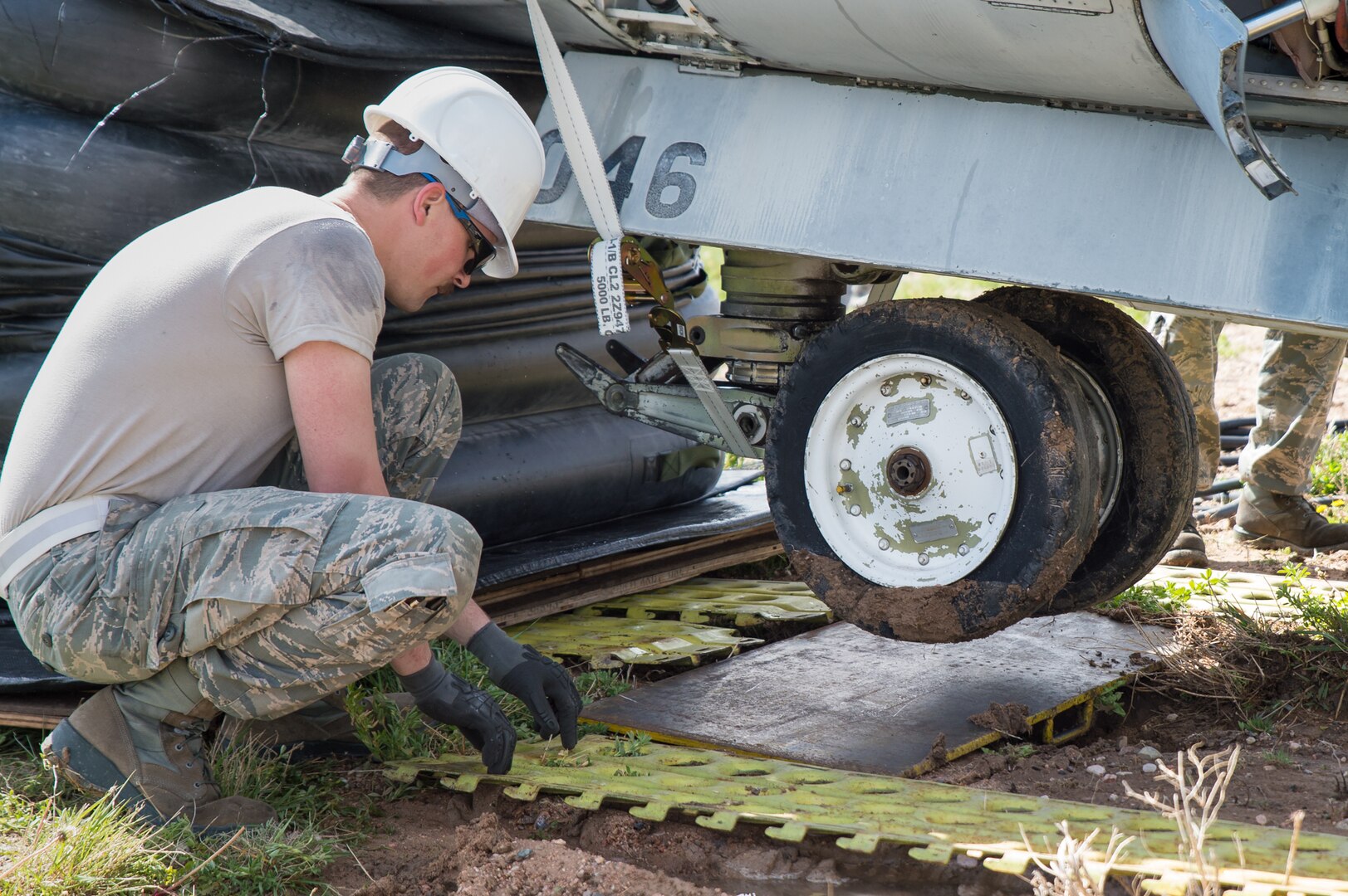 U.S. Air Force Staff Sgt. Ronald Bahre with the 153rd Maintenance Group's Crash Damage or Disabled Aircraft Recovery team places steel planking beneath the front landing gear of an A-7 Corsair II aircraft, May 11, 2017 in Cheyenne, Wyoming. Maintainers from all aircraft specialties practiced moving a fighter aircraft from the mud into a parking spot as part of an annual CDDAR requirement. (U.S. Air National Guard photo by Senior Master Sgt. Charles Delano/released)