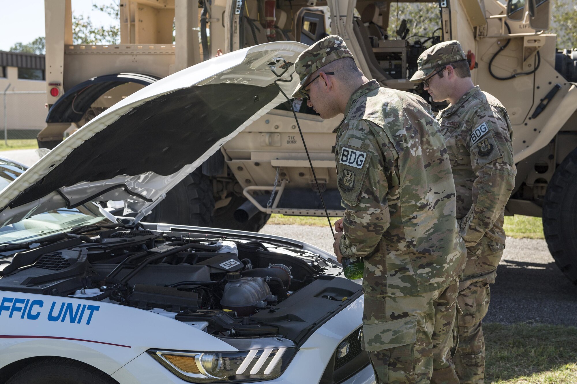 Airmen from the 820th Base Defense Group look at the engine of a local police car during the Police Week car show, May 16, 2017, at Moody Air Force Base, Ga. Different law enforcement vehicles were put on display for attendees to climb in and ask questions about. (U.S. Air Force photo Senior Airman Janiqua P. Robinson)